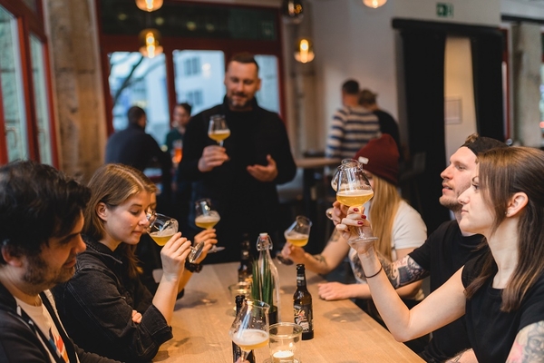 Fröhliche Menschen am Tisch die Bier trinken